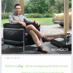 Mężczyzna w fotelu relaksuje się przy dużym oknie z widokiem na ogród i zaparkowany samochód, logo Schüco w prawym dolnym rogu.
