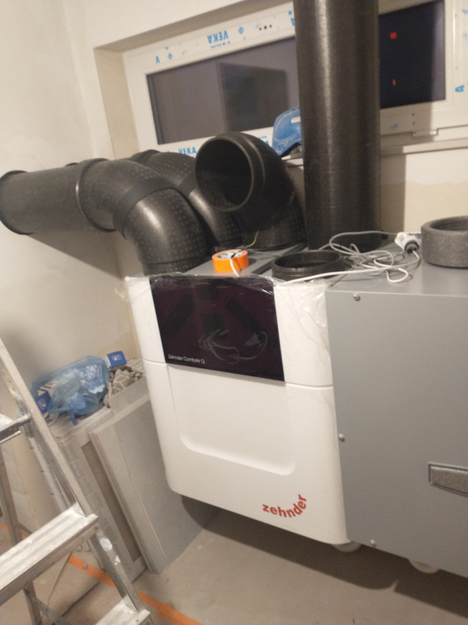 Rekuperator Zehnder ComfoAir Q z podłączonymi przewodami wentylacyjnymi w Kaskach, widoczna drabina i elementy instalacji.