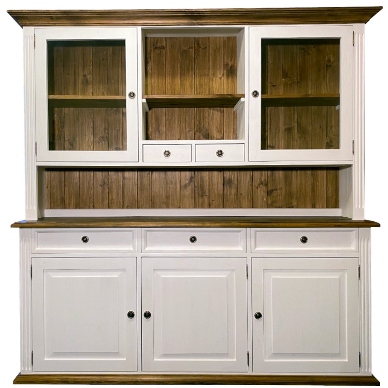 Dwuczęściowy kredens w stylu rustykalnym, z przeszkloną górną częścią i drewnianym wykończeniem, białe fronty szafek i szuflad, ciemnobrązowy blat i podstawa, widoczne okucia w kolorze czarnym.