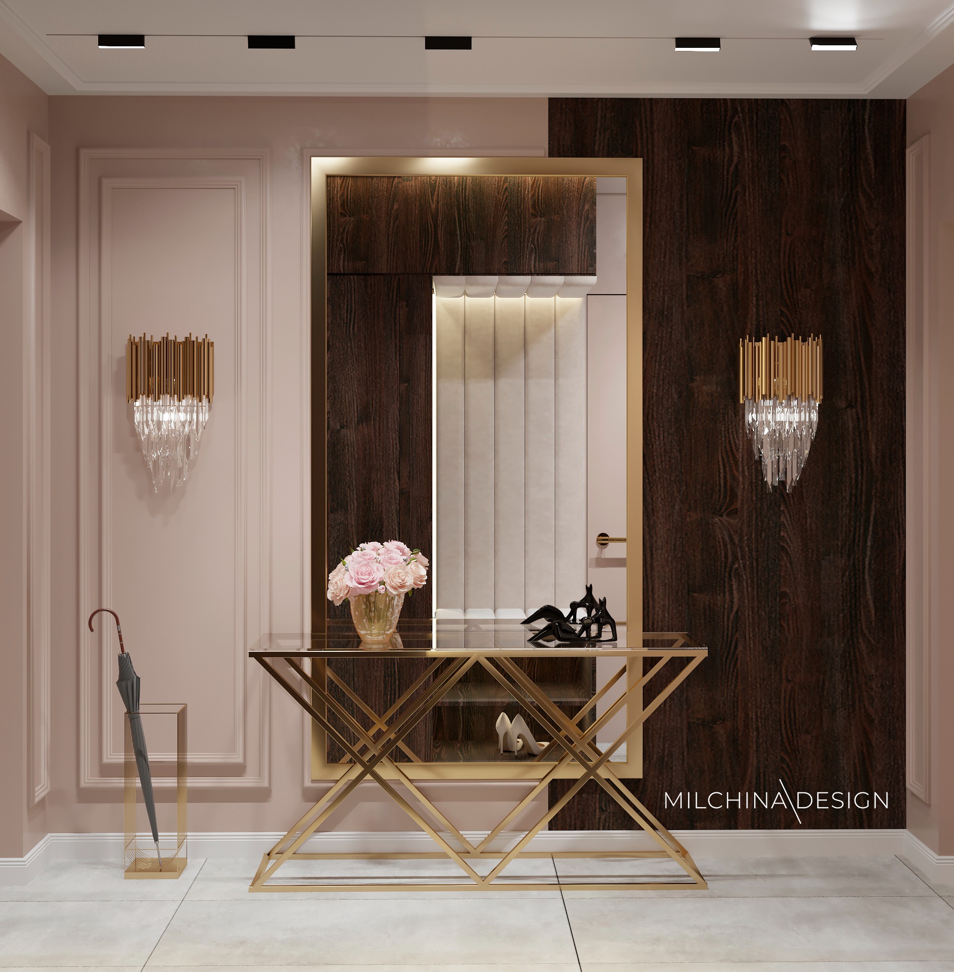 Elegancki hol z konsolą o złotej, geometrycznej konstrukcji, na której stoi wazon z różowymi różami i czarne figurki. W tle lustro w złotej ramie i tapicerowany panel. Na ścianach kinkiety...
