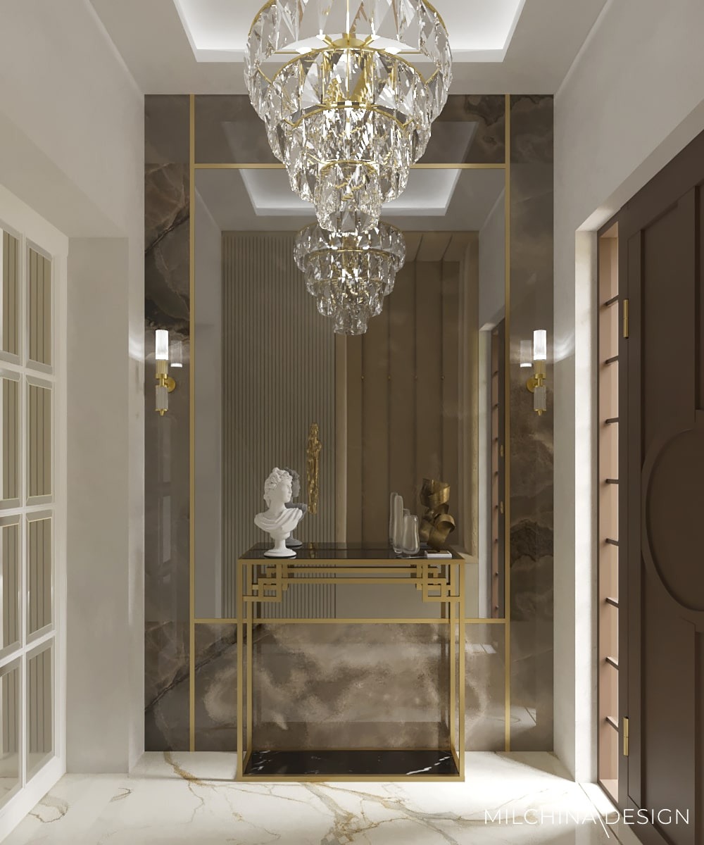 Elegancki hol w Krakowie z marmurową podłogą, kryształowym żyrandolem i konsolą ze złotymi detalami, na której ustawiono popiersie i dekoracyjne wazony.