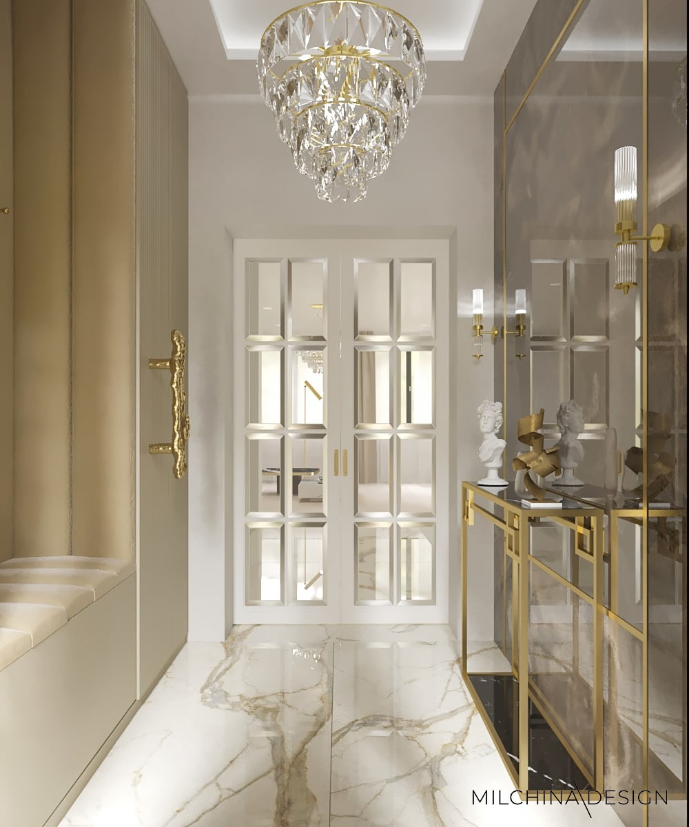 Elegancki hol w odcieniach beżu i złota z kryształowym żyrandolem, marmurową posadzką i konsolą ze szklanym blatem, doświetlony kinkietami.