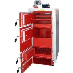 Otwarty piec centralnego ogrzewania z trzema drzwiczkami, widoczne wewnętrzne przegrody i ruszt, kolor czerwony i szary, na górze wentylator i panel sterowania.