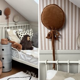 2 RAZY K - Pokój dziecięcy na poddaszu: białe łóżko, paski na ścianie, pluszowy miś i poduszki w kształcie balonów. Przytulna aranżacja z subtelnymi dekoracjami.