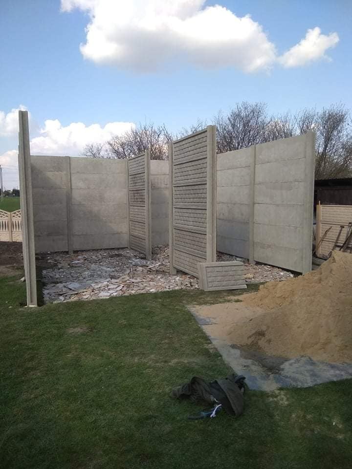 Montaż prefabrykowanego ogrodzenia betonowego w Sochaczewie, widoczne elementy konstrukcyjne i przygotowany teren.