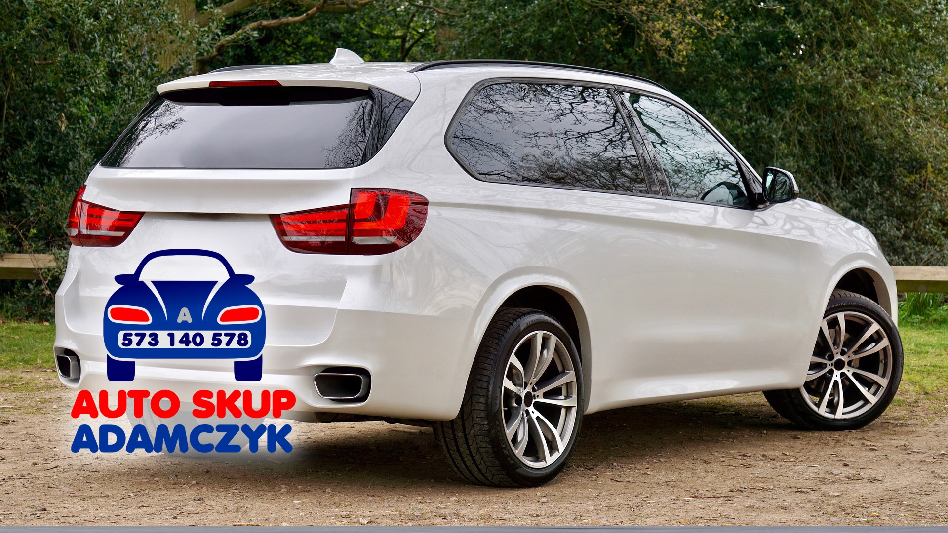 Biały SUV z widocznym logo firmy skupującej auta nałożonym cyfrowo na tylną klapę, na tle zieleni.
