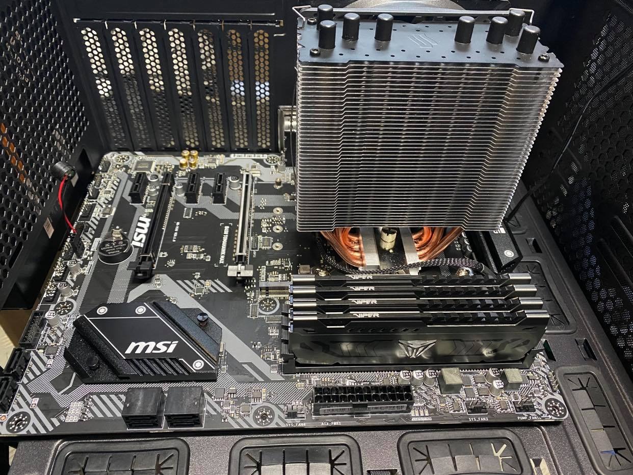 Płyta główna MSI z zainstalowanym chłodzeniem procesora typu tower z miedzianymi rurkami cieplnymi i czterema modułami pamięci RAM Viper, zamontowana w obudowie komputera.