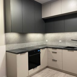 Masalon Design - Nowoczesna kuchnia w odcieniach szarości i beżu z czarnymi akcentami. Górne szafki grafitowe, dolne beżowe. Blat z kamienia. Oświetlenie LED pod szafkami.