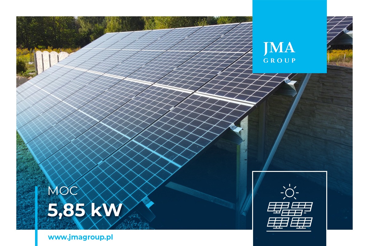 Instalacja fotowoltaiczna o mocy 5.85 kW na gruncie, widoczna z boku, z fragmentem ogrodzenia w tle i logo firmy JMA Group
