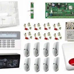 Kompletny zestaw urządzeń alarmowych marki Satel, zawierający centralę alarmową z manipulatorem, akumulator, transformator, czujki ruchu oraz sygnalizator akustyczno-optyczny.