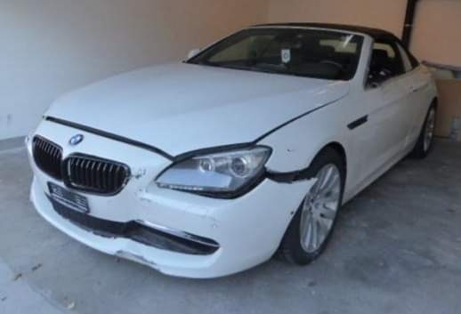 Uszkodzony przód białego BMW cabrio po kolizji, widoczne pęknięcia i zarysowania na zderzaku i błotniku, Nakło Śląskie.