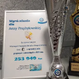 Dyplom i srebrna statuetka PZU dla Anny Przybyłowskiej, najlepszego doradcy ubezpieczeniowego w 2021 roku w sprzedaży polis grupowych i zdrowotnych, z liczbą 253 949 na dyplomie.
