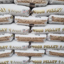Stos worków z pelletem drzewnym, widoczne certyfikaty ENplus A1 i logo producenta Anpol, każdy worek o wadze 15 kg.