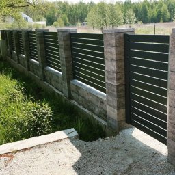 Wytwórnia i Wyroby z Drutu Łukasz Kraska - Nowoczesne ogrodzenie panelowe z bramą w kolorze grafitowym, z poziomymi szczeblami, wsparte na słupkach z szarej kostki. Otoczenie: trawa i drzewa.