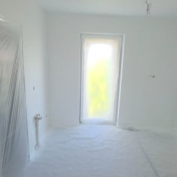 EDE GROUP SPÓŁKA Z OGRANICZONĄ ODPOWIEDZIALNOŚCIĄ - Białe, świeżo pomalowane wnętrze pokoju z zakrytymi folią oknami i podłogą. Widoczne wystające kable z sufitu. Przygotowanie do dalszych prac wykończeniowych.