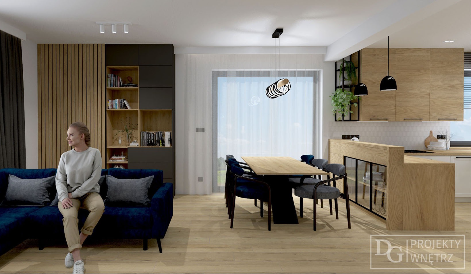 Wnętrze: kobieta siedzi na granatowej sofie w salonie z drewnianą zabudową, regałem i stołem jadalnym. Widok na kuchnię z drewnianymi szafkami i zielonymi roślinami.