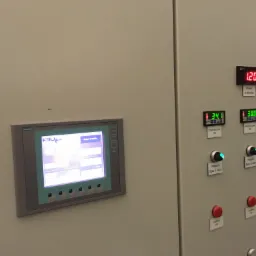 Panel sterowania z ekranem dotykowym Siemens Simatic Panel Touch, wyświetlającym schemat technologiczny, oraz cyfrowymi wskaźnikami poziomu i temperatury zbiorników, przełączniki trybu pracy pomp.