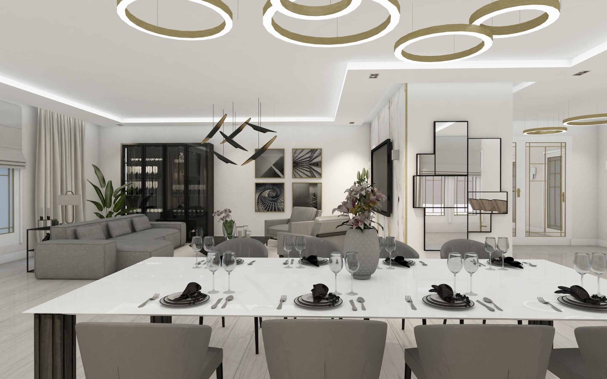 Elegancka jadalnia w nowoczesnym stylu z długim białym stołem, szarymi krzesłami, zastawą stołową i dekoracyjnym oświetleniem sufitowym. W tle salon z szarą sofą, przeszkloną witryną...