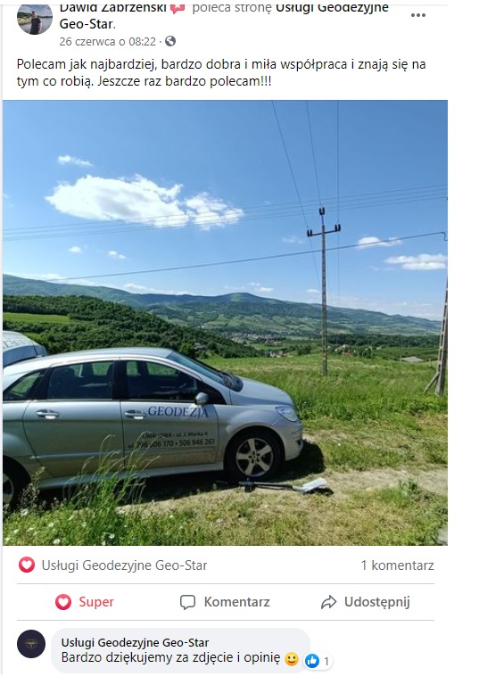 Srebrny samochód z napisem 'Geodezja' i numerami telefonów na tle zielonych wzgórz i błękitnego nieba z liniami wysokiego napięcia, sprzęt geodezyjny leżący obok pojazdu.