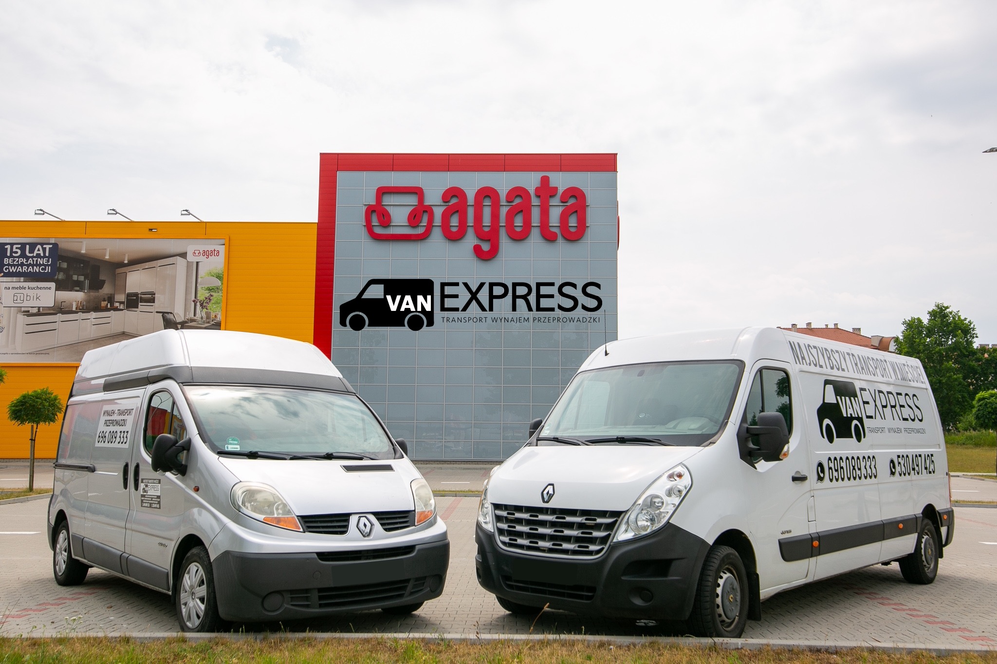 Dwa busy firmy Van Express zaparkowane przed budynkiem Agata Meble z reklamą kuchni, oferujące transport, wynajem i przeprowadzki.