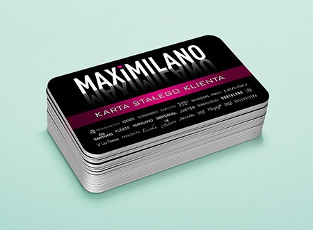 Stos czarnych kart stałego klienta z zaokrąglonymi rogami, z białym napisem 'MAXIMILIANO' i różowym paskiem z tekstem 'KARTA STAŁEGO KLIENTA' na jasnoniebieskim tle.