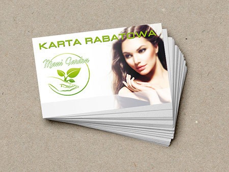 Stos kart rabatowych z zielonym logo i wizerunkiem kobiety na beżowym tle.
