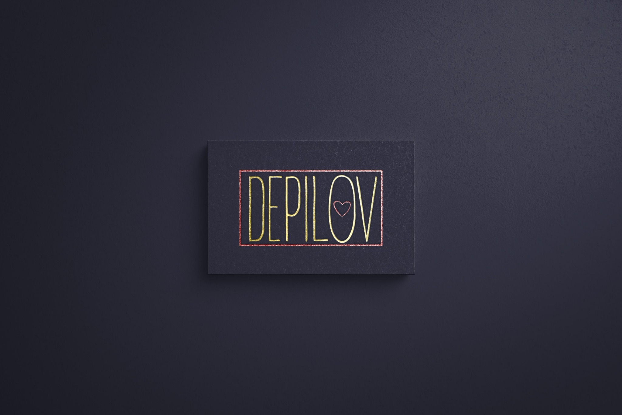Czarna wizytówka z błyszczącym, złotym napisem 'DEPILOV' w ozdobnej ramce z sercem zamiast litery 'O', leżąca na ciemnym, matowym tle.