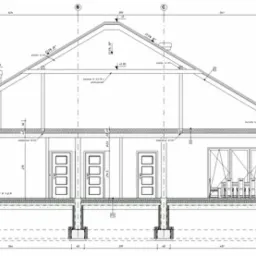 Przekrój poprzeczny projektu domu jednorodzinnego z widocznymi fundamentami, ścianami, stropem, więźbą dachową i kominem, zawierający szczegółowe wymiarowania i opisy techniczne.