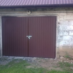 Krzysztof Orłowski - Brązowa, dwuskrzydłowa brama garażowa z metalu, z zamkiem na środku, zamontowana w murowanym garażu z widocznymi śladami użytkowania i roślinnością po bokach.