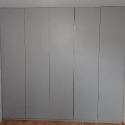 Szara szafa wnękowa z sześcioma drzwiami, zlicowana ze ścianą, na drewnianej podłodze, widoczna z perspektywy wnętrza pomieszczenia.