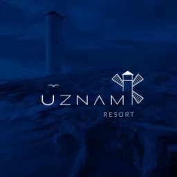 Nocny widok na morze z latarnią morską w tle i logo UZNAM Resort na pierwszym planie.