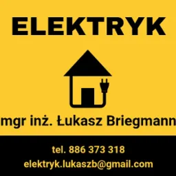 Żółto-czarne logo elektryka: napis 'ELEKTRYK' nad symbolem domu z wtyczką, imię i nazwisko mgr inż. Łukasz Briegmann, numer telefonu i adres email.