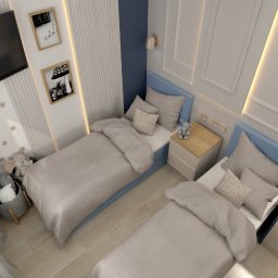 MAC-Project / Architektura, projektowanie, aranżacja wnętrz - Nowoczesny pokój dziecięcy z dwoma łóżkami, niebieskimi zagłówkami i jasną pościelą. Ściany z ryflowanymi panelami, sztukaterią, telewizorem i obrazami. Drewniane szafki nocne, regał, zabawki.