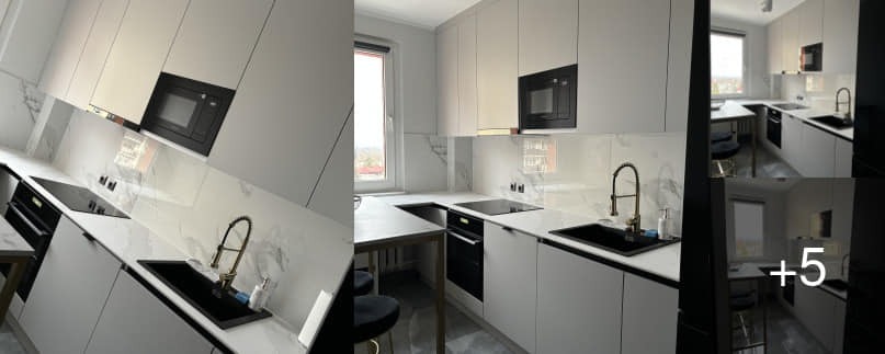 Nowoczesna kuchnia z białymi szafkami, blatem imitującym marmur, czarnym zlewem i złotą baterią, uzupełniona o czarne AGD w zabudowie.