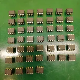 Równomiernie ułożone układy scalone DIP-8 na zielonym tle, widoczne oznaczenia '4558C KK7818' oraz logo producenta.