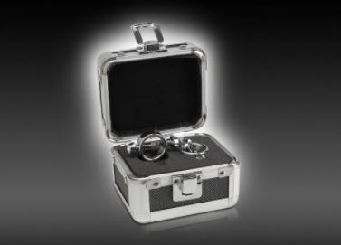 Otwarta srebrna walizeczka z czarnym wnętrzem, zawierająca dwa metalowe pierścienie na czarnym, piankowym podłożu.