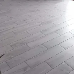 Ułożone panele podłogowe imitujące drewno w Karlinie, widoczna ściana pomalowana na dwa kolory: biały i ciemny turkus.