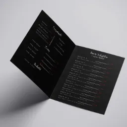 Rozłożona, dwustronicowa karta menu restauracji z czarnym tłem i białym, minimalistycznym tekstem, prezentująca dania kuchni indyjskiej i tajskiej z cenami.