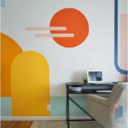 Pomysłowo pomalowana ściana w biurze z geometrycznymi kształtami: pomarańczowe koło, żółte łuki i pastelowe akcenty, czarne biurko z laptopem i beżowe krzesło na kółkach, dywan w tle.