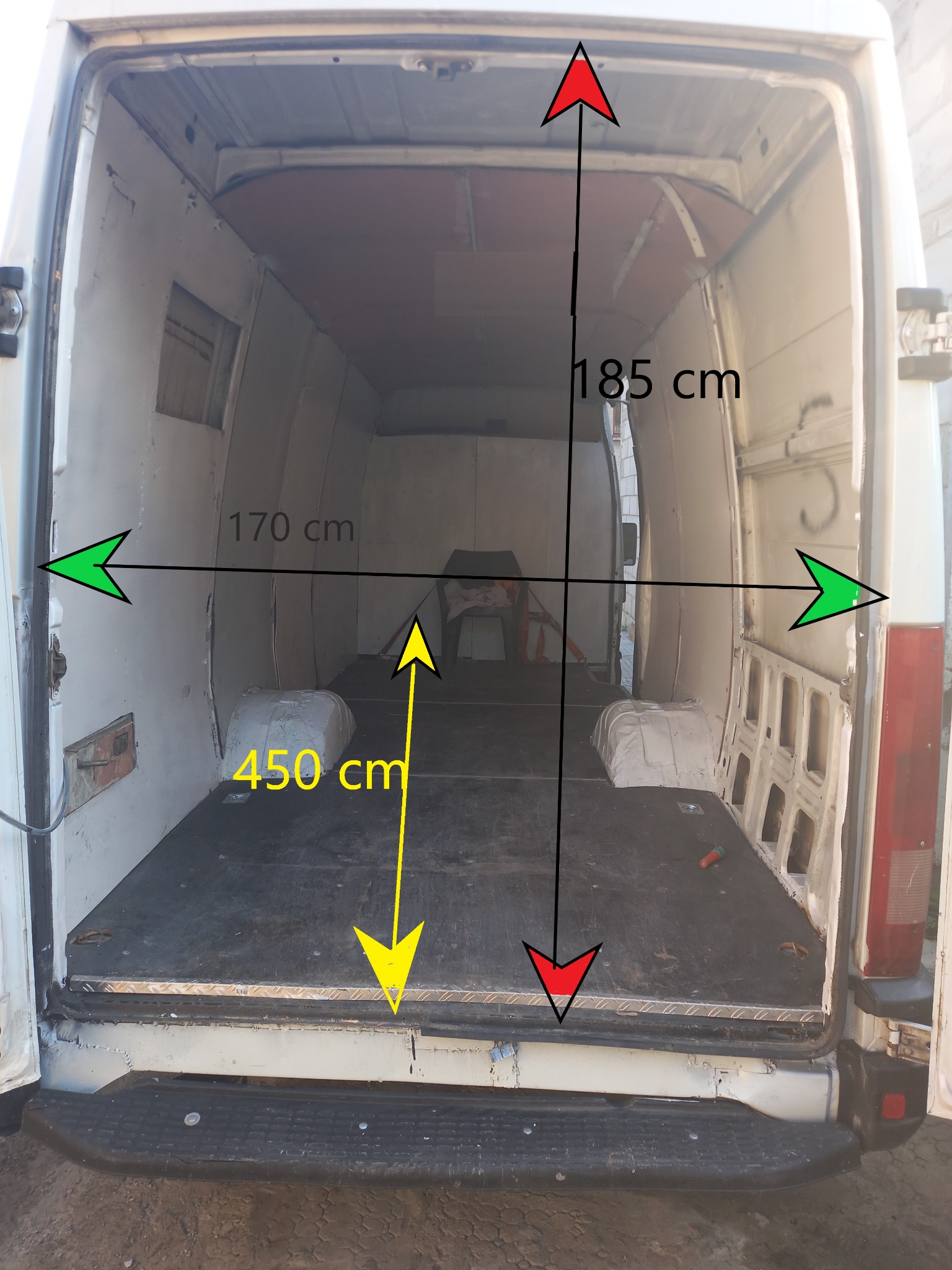 Wnętrze pustego, białego busa z otwartymi drzwiami, widoczne wymiary: wysokość 185 cm, szerokość 170 cm, głębokość 450 cm.