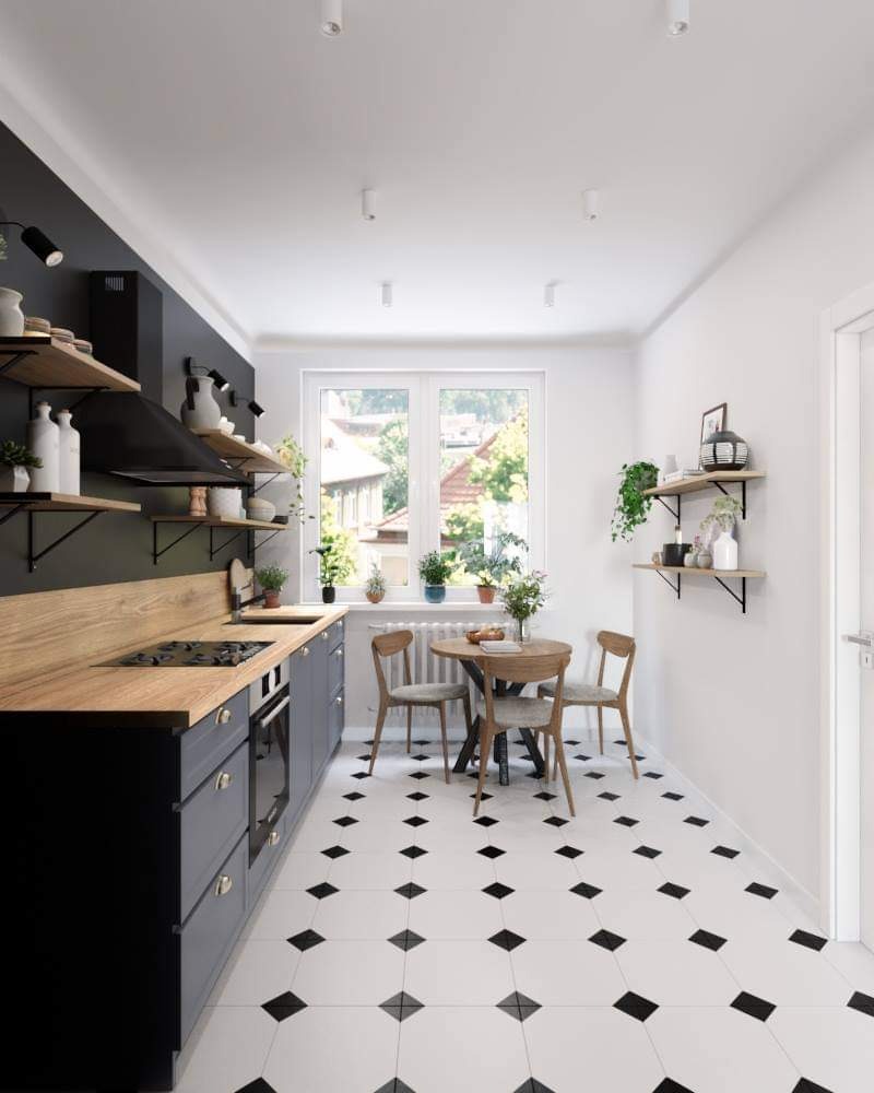 Wnętrze kuchni w stylu skandynawskim z czarno-białą podłogą w romby, drewnianym blatem, szarymi szafkami i okrągłym stołem z trzema krzesłami przy oknie.