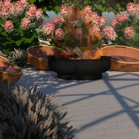 Ognisko w czarnym palenisku otoczone ozdobnymi, drewnianymi donicami z roślinnością w ogrodzie, rzucające cienie na jasną nawierzchnię.