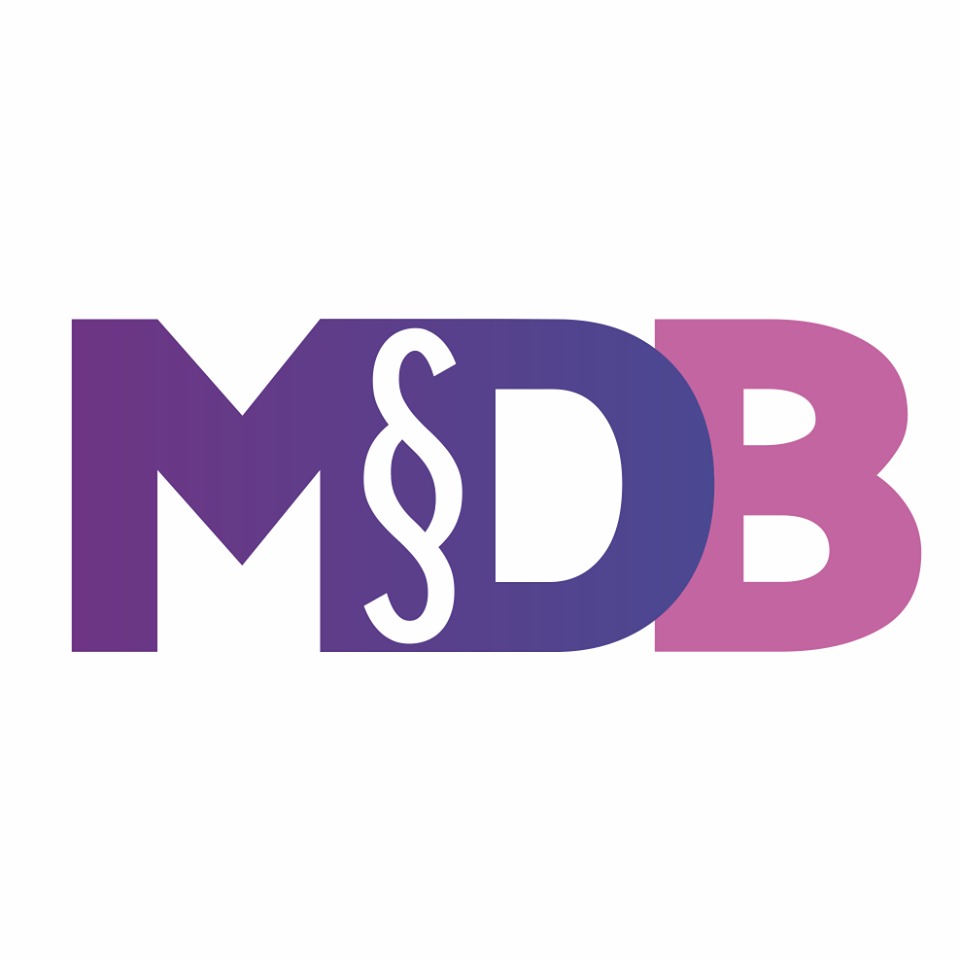 Logo firmy MDB z symbolem paragrafu, gradient fioletowo-różowy na białym tle.