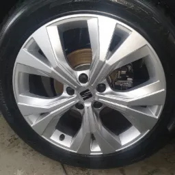 Błyszczące, aluminiowe felgi samochodu marki Seat, z widocznymi śladami wody na oponie, po zabiegu czyszczenia i konserwacji.