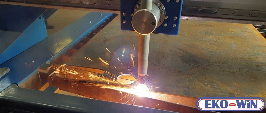 Automatyczne cięcie plazmowe blachy stalowej z iskrami, widoczny fragment logo 'EKO-WIN' w prawym dolnym rogu.