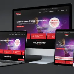 Responsywna strona internetowa z ofertą ekskluzywnych trofeów i upominków, wyświetlana na monitorze, laptopie, tablecie i smartfonie, prezentująca spójny wygląd na różnych urządzeniach.