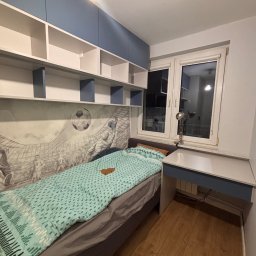 Meble Zbyszek - Pokój młodzieżowy z łóżkiem, biurkiem i szafkami wiszącymi w kolorach bieli i błękitu. Na ścianie fototapeta z motywem piłkarskim. Lampka na biurku.