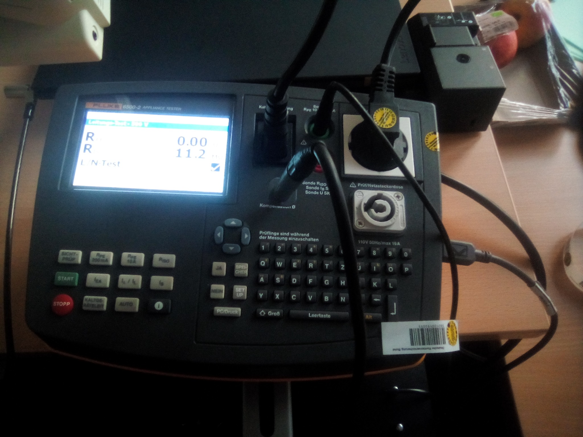 Miernik elektryczny Fluke 6500-2 Appliance Tester z podłączonymi przewodami, wyświetlający wyniki pomiarów na ekranie LCD.