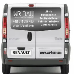 Tył białego samochodu dostawczego Renault Trafic z naklejonym logo firmy WR BAU oferującej usługi budowlane, brukarskie i prace ogrodowe oraz kontakt telefoniczny i adres e-mail, a także listę...