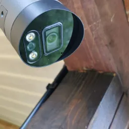 Szara kamera tubowa BCS zamontowana pod drewnianą konstrukcją z widocznym logo firmy.